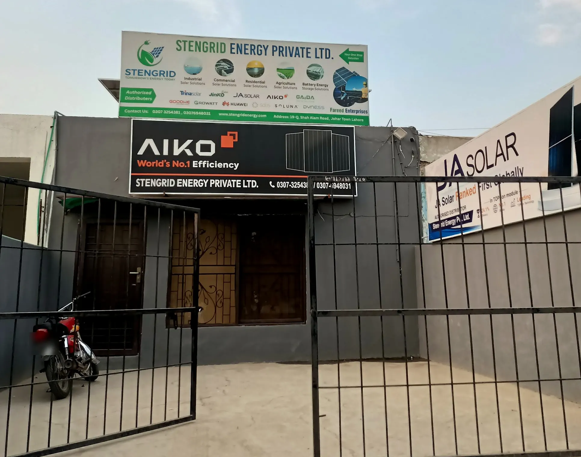 StenGrid Energy Private Ltd. office at 19-Q, Shah Alam Road, Johar Town, Lahore, with AIKO and JA Solar signboards